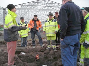 Figur 1. Våra grannar från NCC kom för att se hur keramikkärlet med den gravlagdes brända ben togs fram ur gravens inre. Foto Anna Maria Renck, Arkeologikonsult.